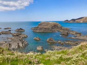 a view of the ocean with rocks in the water at Montgomery Barn in Bideford