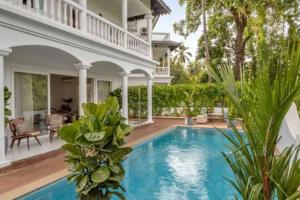 a large house with a swimming pool in a yard at Amananjuna 2 · Luxurious 5bhk villa in Anjuna in Goa