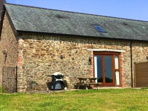 a stone building with a table and a picnic table at Montgomery Barn in Bideford