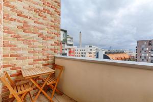 a balcony with two chairs and a brick wall at Résidor - Lumineux Duplex à saint Ouen in Saint-Ouen