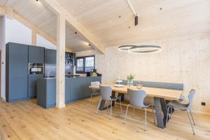 德哥米斯的住宿－Naturchalets Turracher Höhe by ALPS RESORTS，厨房以及带木桌和椅子的用餐室。