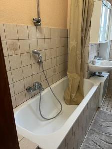 een badkamer met een bad, een douche en een wastafel bij Gästewohnung 1 OGR in der Nähe zur Veltinsarena - Gästewilli 1 in Gelsenkirchen