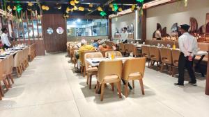 un comedor con gente sentada en las mesas de un restaurante en Hotel welcome somnath en Somnāth