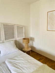 1 dormitorio blanco con 1 cama y 1 silla en Chiemsee Ferienwohnung Gartenblick en Prien am Chiemsee