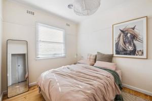 1 dormitorio con 1 cama grande y espejo en Hazel House Ballarat, en Wendouree
