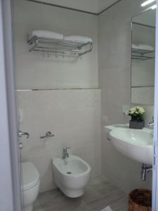 a white bathroom with a sink and a toilet at Il Lido in Giannella