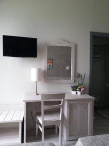Zimmer mit einem Schreibtisch, einem Stuhl und einem Spiegel in der Unterkunft Il Lido in Giannella