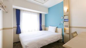 a bedroom with a white bed and a window at Toyoko Inn Tokyo Kamata No 1 in Tokyo