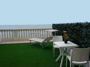 un patio con tavoli, sedie e vista sull'oceano di Il Lido a Giannella