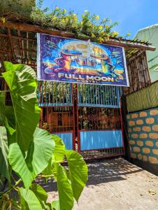 a building with a painting on the side of it at Full Moon Hostel - Beer Pong Central in Coron