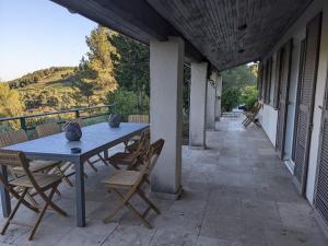 un patio con mesa y sillas en un porche en Provençal house between sea and vineyards, en Le Beausset