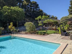 una piscina en un patio con jardín en Provençal house between sea and vineyards, en Le Beausset