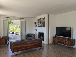 sala de estar con TV de pantalla plana y sofá en Provençal house between sea and vineyards, en Le Beausset