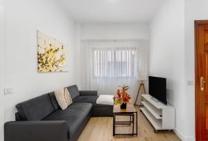 a living room with a couch and a tv at Apartamento Bellavista, bajo Alcalá in Guía de Isora