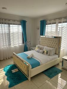 een slaapkamer met een groot bed en blauwe gordijnen bij Nyachaba Apartment in Kisumu