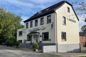 un edificio blanco sentado al lado de una calle en Hotel Restaurant Artemis, en Willich
