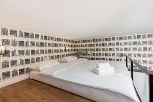 a bedroom with a bed with a wall covered in photos at Starowiślna 36 Apartment with Mezzanine in Krakow