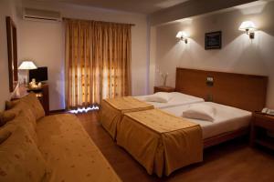 una habitación de hotel con dos camas y un sofá en Hotel Santa Mafalda, en Fátima