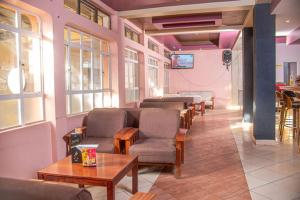 a waiting room with a row of chairs and tables at Hotel Wagon Wheel in Nakuru