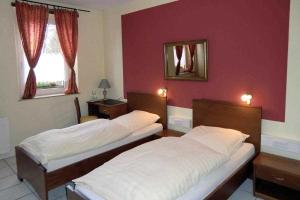 2 camas en una habitación con paredes rojas en Hotel Restaurant Artemis en Willich