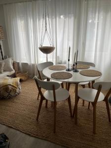 a dining table and chairs in a living room at Hangon helmi pariskunnalle tai yksin matkustavalle in Hanko
