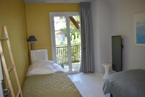 Schlafzimmer mit einem Bett und einer Glasschiebetür in der Unterkunft Hautes Pyrénées Les Roses dAdour in Moulédous