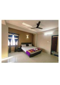 a bedroom with a bed and a ceiling fan at Hotel UK Palace Puri Near Sea Beach Best Seller in Puri