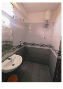 a bathroom with a sink and a toilet and a mirror at Hotel UK Palace Puri Near Sea Beach Best Seller in Puri