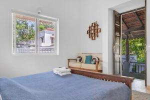 a bedroom with a blue bed and two windows at Villa Divina · Luxurious 4BHK Villa in Candolim in Goa +64 photos