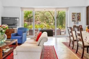 a living room with a white couch and chairs at Villa Divina · Luxurious 4BHK Villa in Candolim in Goa