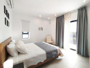 a white bedroom with a bed and a window at Silver Cozy Getaway - 3 Pearls Pool Retreat in Dhémbla
