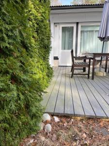 a wooden deck with a bench and a table at Hangon helmi pariskunnalle tai yksin matkustavalle in Hanko