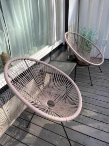 two chairs sitting on a porch next to a window at Hangon helmi pariskunnalle tai yksin matkustavalle in Hanko