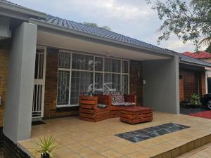 a house with a patio with a couch in front of it at Grand Diamond Lodge in Roodepoort