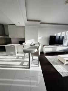 a living room with a table and a kitchen at Kiralık Daire - Ritz Carlton Residance Süzer Plaza'da Eşyalı Manzaralı in Istanbul