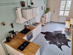 une cuisine avec des placards blancs et un comptoir dans l'établissement Charming Studio-Perfect Getaway, à Nummistenkylä