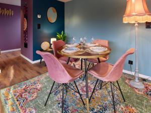 a dining room with a table and pink chairs at Lacuna VITA by Sonnevijver Residences in Lanaken