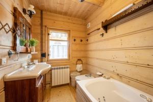 a bathroom with a tub and a sink at Sweet Home Sweet APARTZAKOP in Kościelisko
