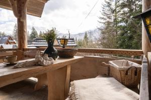 a porch with a table and a view of the mountains at Sweet Home Sweet APARTZAKOP in Kościelisko