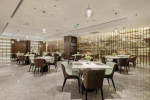 a restaurant with tables and chairs in a room at Radisson Hotel, Beijing DaXing Airport in Beijing