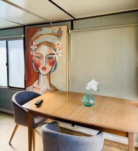 a room with a table and a painting of a woman at Mornington Peninsula Retro Caravans in Rye