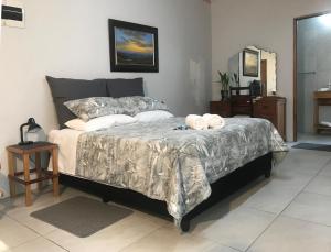 a bedroom with a bed with two towels on it at Kunsvilla in Durbanville