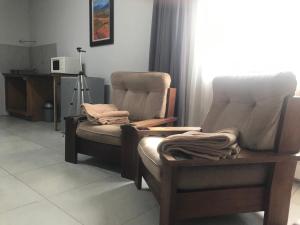 duas cadeiras sentadas num quarto com uma janela em Kunsvilla em Durbanville