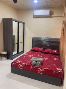 una camera con letto e piumone rosso di B&K Homestay Lahad Datu a Lahad Datu