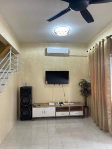 ラハダトゥにあるB&K Homestay Lahad Datuのリビングルーム(シーリングファン、薄型テレビ付)
