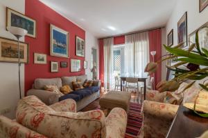 salon z czerwonymi ścianami i niebieską kanapą w obiekcie Cipro Apartment with balconies w Rzymie