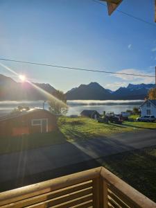 a view of a lake from a house with a fence at House with a wiew in Lenangsøyra