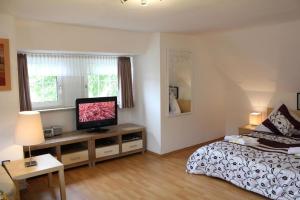 Schlafzimmer mit einem Bett und einem Flachbild-TV in der Unterkunft Komfortables Ferienhaus in Daun mit Großer Terrasse in Daun