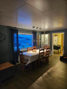 a dining room with a table and chairs with a view of the ocean at House with a wiew in Lenangsøyra