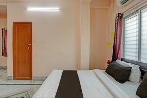 a bedroom with a bed and a window and a door at Hotel O Aarshi Palace in Cuttack +25 photos